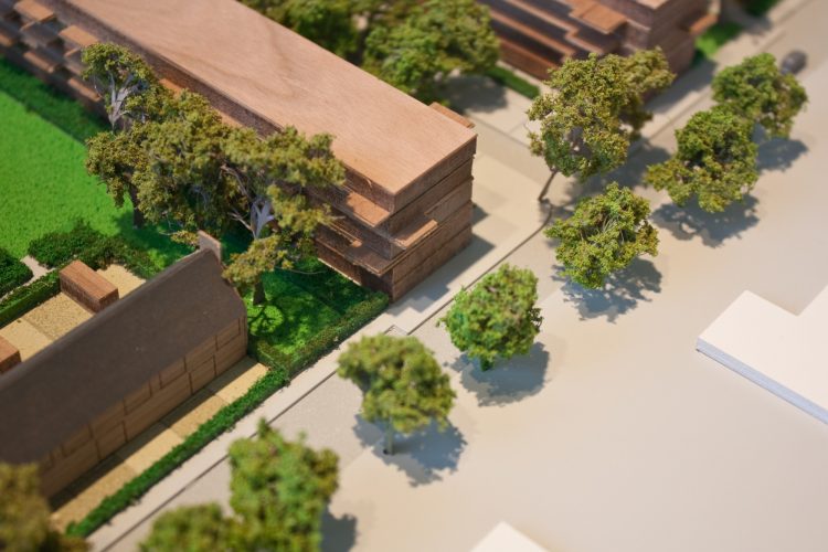 a model of small apartment buildings surrounded by trees and green space
