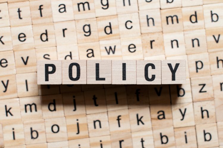 A page of wooden scrabble letters with POLICY spelt out