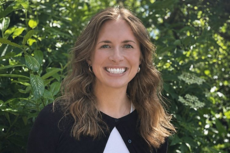 a photo of Emma Ranking smiling with a leafy background