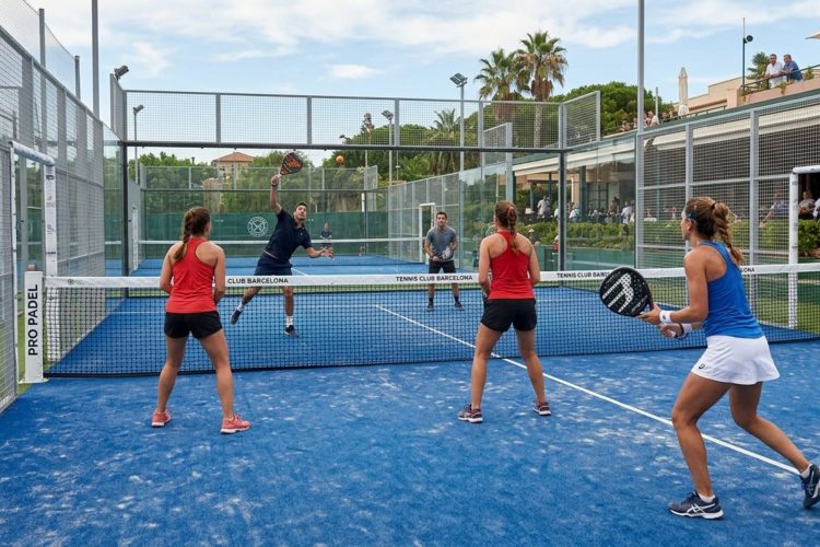 A picture of a padel court with 4 players, blue surface